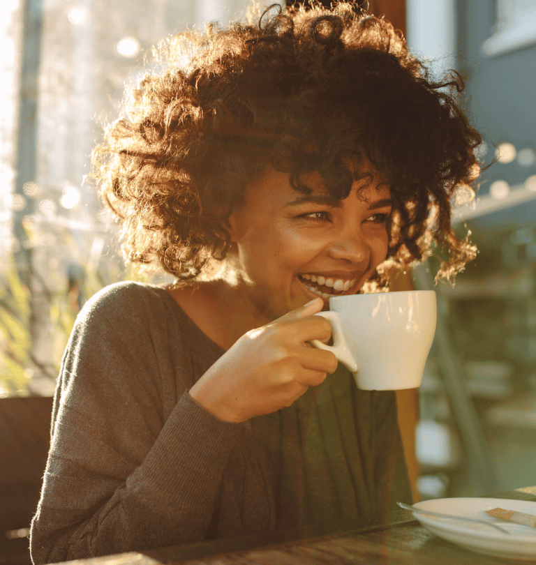 Kvinna som glatt dricker kaffe